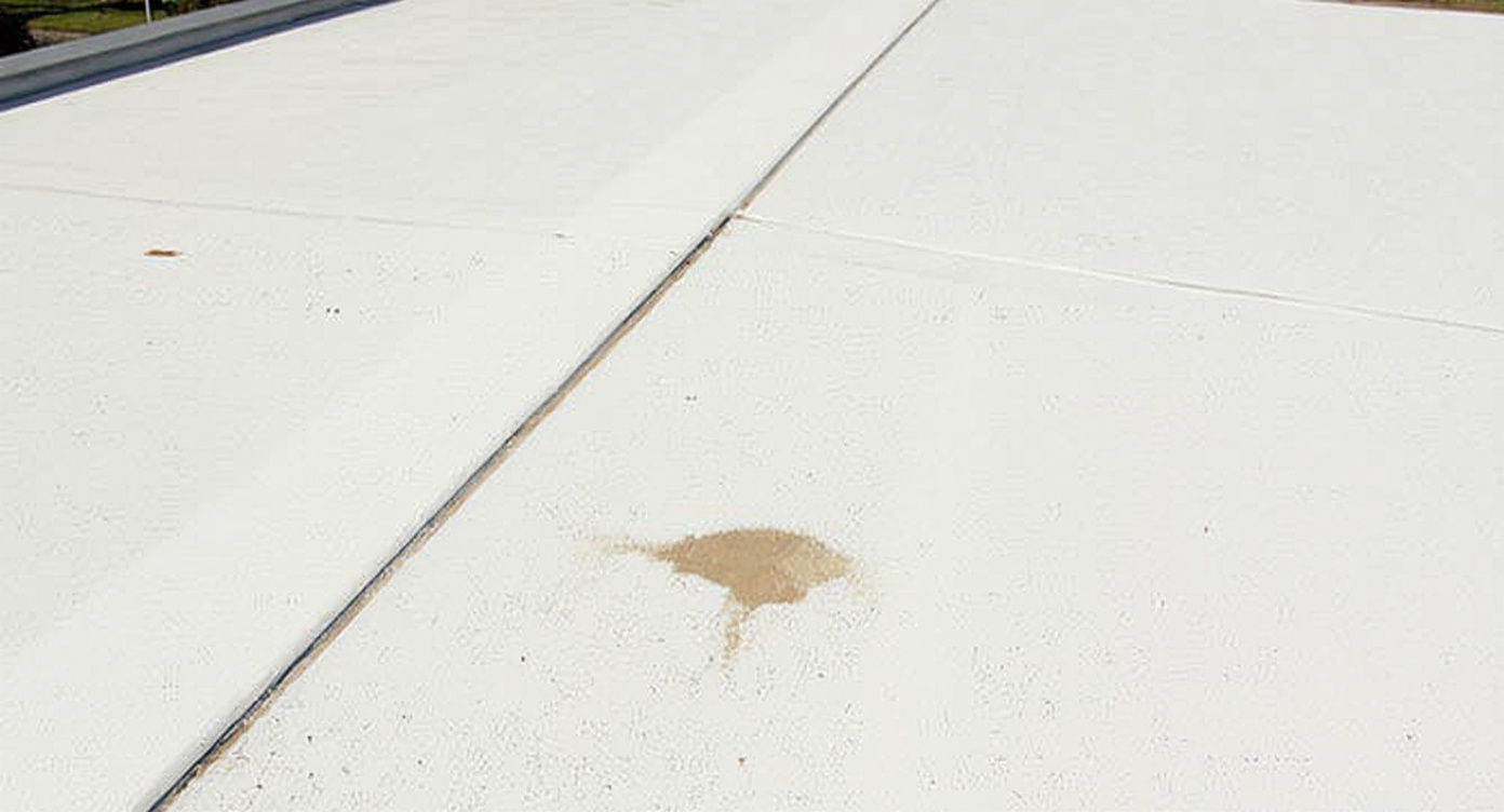 White TPO thermoplastic polyolefin flat roofing membrane showing the smooth surface and heat-welded seam line used on low-slope Gulf Coast commercial and residential flat roofs